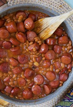 beans and sausage in a pot with a wooden spoon