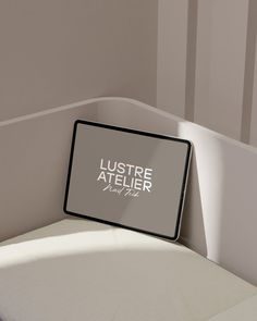 there is a sign that says lustre atelier next to the bed headboard