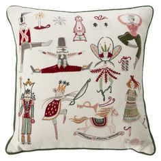 a white pillow with various embroidered designs on the front and back of it, including an image of people