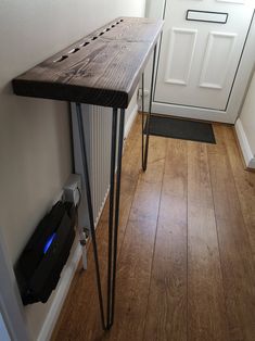 a wooden table sitting on top of a hard wood floor next to a white door