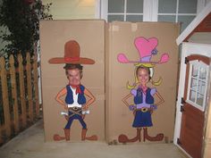 two cardboard boxes are decorated with children's costumes and decorations, one has a cowgirl and the other is a cowboy