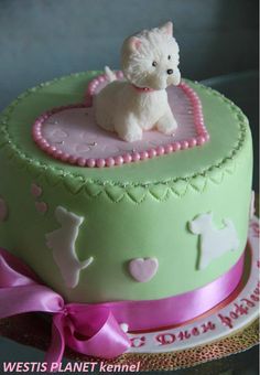 a cake decorated with a small white dog sitting on top of it