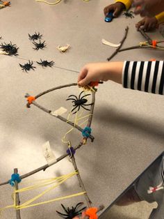 children are playing with toys made out of sticks and spider webs on the floor