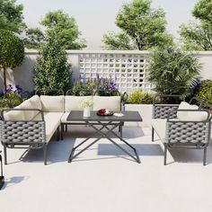 an outdoor seating area is shown with chairs, tables and potted plants in the background