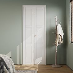 a bedroom with green walls and white closets next to a bed in front of a window