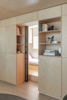 an open door leading to a bedroom with bookshelves and shelves on the wall