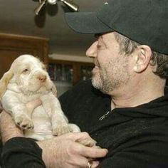 a man holding a puppy in his arms