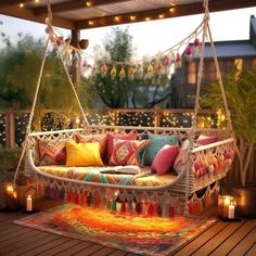 a porch swing with pillows and candles on the floor next to it is lit up by string lights