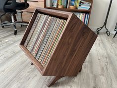 a record player sitting on top of a wooden stand in front of a book shelf