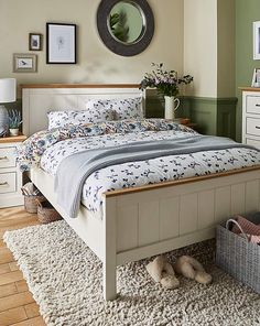 a bedroom with a bed, dressers and baskets on the floor in front of it