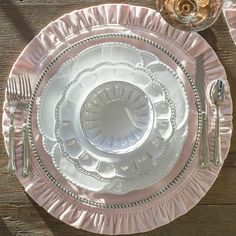 an empty plate on a wooden table with silverware