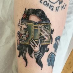 a woman's leg with a book and flowers on it that says, long at all