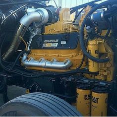 there is a yellow caterpillar engine in the back of a truck with its hood open