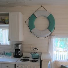 a kitchen with a stove top oven sitting next to a white refrigerator freezer under a life preserver