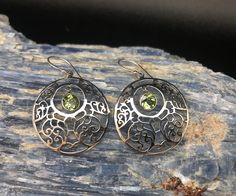 Circular Peridot Earrings // Filigree Bali Setting // 925 Sterling Silver Length: 1.75 inches Weight: 5 grams Stone: peridot Hallmark 925 Very light weight for the size, the stone dangles freely from within. Note: please pay attention to the size and weight before purchasing. This is a very delicate and light weight earring. Handmade Peridot Round Earrings, Handmade Round Peridot Earrings, Nickel-free Round Peridot Earrings, Peridot Earrings, Labradorite Ring, Silver Prices, Labradorite Pendant, Light Weight Earrings, Favorite Rings