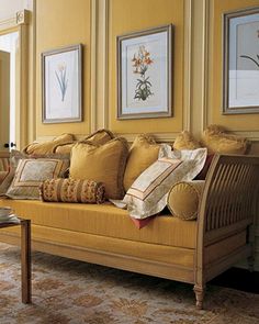 a living room filled with furniture and paintings on the wall