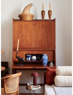 a room with a desk, chair and vases on top of it