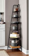 a shelf with pots and pans on it in the corner of a room next to a kitchen