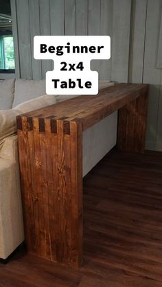 a wooden table sitting on top of a hard wood floor next to a white couch