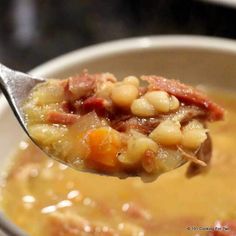 a spoon full of soup with beans and ham