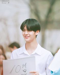 a young man holding up a sign that says 10th anniversary