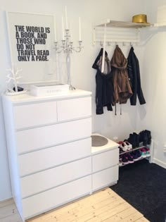 a white dresser sitting next to a closet filled with shoes and coat racks on top of it