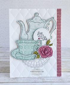 a card with a teapot and rose on it