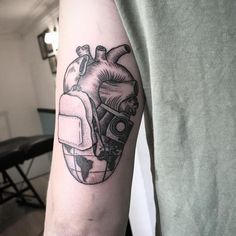 a man with a heart tattoo on his arm