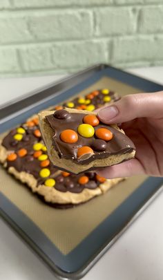 a person holding up a piece of food with candy on it