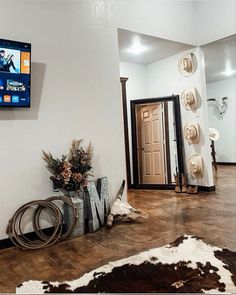 a television mounted to the wall in a living room next to a cowhide rug