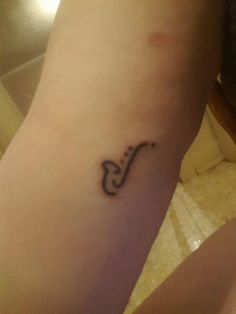 a person with a small tattoo on their arm that has a musical note on it