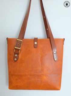 This hand made leather tote bag can have many uses including as a handbag, shopping bag, gym bag, baby items or anything else you can think of!The main body of the bag is made from a single continuous piece of leather for maximum strength and minimal seams. The straps adjust by means of two solid brass conway buckles to suit either shoulder or hand carry (instructions are included, please see photos for measurements).✾ Details:✤ main bag is made from tan coloured cowhide (fully lined with the sa Large Brown Bags With Leather Handles, Waxed Finish Tote Shoulder Bag For Shopping, Dark Tan Leather Handled Tote Satchel, Dark Tan Tote Satchel For Everyday Use, Dark Tan Leather Handles Satchel Tote, Dark Tan Tote Satchel, Waxed Finish Satchel Shoulder Bag For Shopping, Brown Large Capacity Shoulder Bag In Vegetable Tanned Leather, Large Capacity Brown Vegetable Tanned Leather Shoulder Bag