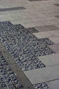 an umbrella sitting on top of a tiled sidewalk