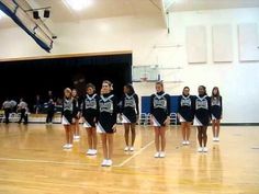 a group of cheerleaders standing on a basketball court