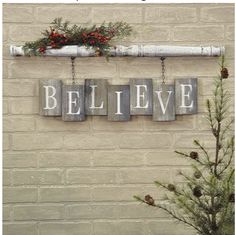 a brick wall with the word believe spelled in wooden letters and hanging from it's side