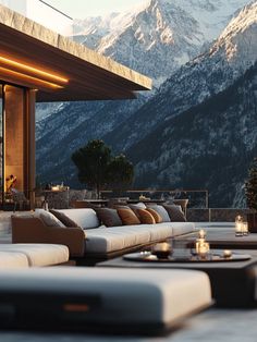 an outdoor lounge area with mountains in the background at dusk, lit by candles and lanterns