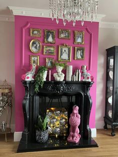 a living room decorated in pink and black with pictures on the wall, candlesticks and other decorations