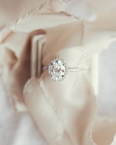 an engagement ring sits on top of a pillow