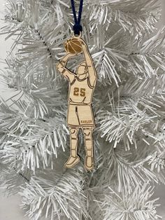 a wooden ornament with a basketball player on it hanging from a christmas tree