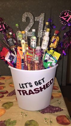 a white bucket filled with lots of alcohol and confetti on top of a table