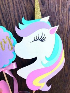 there is a unicorn cake topper on a stick with a pink bow around it