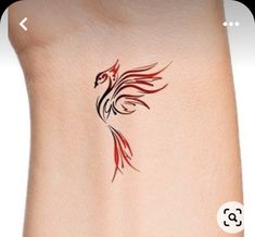 a small tattoo on the side of a woman's arm with a red and black bird