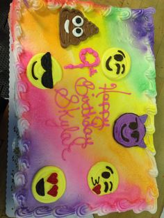 a birthday cake decorated with smiley faces and eyes