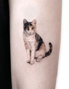 a small cat tattoo on the right thigh, it appears to be an image of a kitten