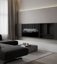 a living room with two black couches and a flat screen tv on the wall