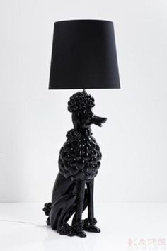 a black poodle lamp sitting on top of a table next to a black shade