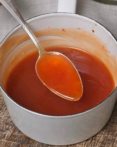 a spoon full of sauce sitting in a pot