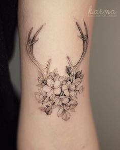 a woman's lower arm with flowers and antelope on the back of her leg