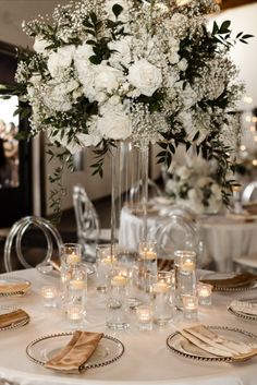 the centerpieces on this table are filled with white flowers