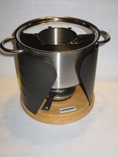 an image of a stove that is on top of a table with wood and metal